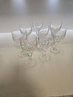 Eight Atlantis crystal wine goblets grouped together, showing their clear cut crystal design and sturdy stems in excellent condition.