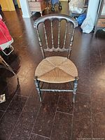 Front view of the vintage wooden chair showing the dark wood frame and woven wicker seat.