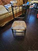 Full view of chair showing turned wood frame and cane seat.