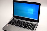 Open Asus laptop powered on showing Windows 10 desktop on screen and keyboard with numeric keypad