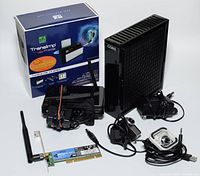 Cogent cable modem, wireless router, PCI WiFi card with antenna, two USB webcams, cables and power adapters, plus MK Mukii TransImp USB 3.0 Hard Drive Dock box