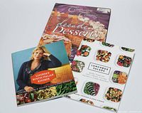 Three cookbooks arranged overlapping. Titles visible: "Company's Coming-Decadent Desserts", "Lunchbox Salads", and "Lucinda's Rustic Italian Kitchen". Covers feature food images and author photo.