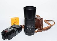 Photo showing Sigma zoom lens, Vivitar flash unit, Kodak Porta 160 film box, and brown leather camera case.