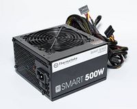 Angle view showing front label of Thermaltake Smart 500W PSU and connected cables.