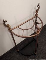 Full view of the vintage Chapman umbrella stand showing the semi-circular base and three dolphin finials on top of vertical supports.