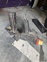 Used Banks 2 in 1 floor nailer and stapler tool for hardwood flooring, showing air hose connector, nail/staple magazine, and adjustment knob. Shows heavy use and dirt.