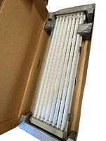 Light therapy lamp panel in protective cardboard packaging with metal grid and multiple fluorescent tubes