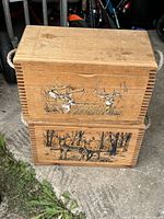Front view of the two stacked wooden crates showing hand painted white tail deer artwork and rope handles