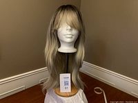 Full front view of the blonde synthetic wig with dark roots on a mannequin head.