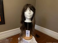 Light brown ombre synthetic wig displayed on a white mannequin head, showing length and color with bangs.