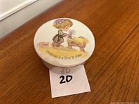 Photo of the trinket box lid showing Precious Moments illustration and text.