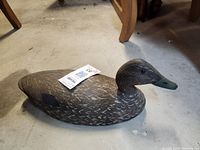 Side view of the black duck decoy showing the detailed feather painting and full body shape.