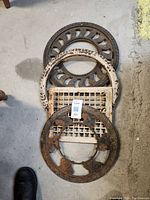 Top view of the four different cast iron grates stacked together showing various patterns and wear.