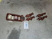 Photo showing full cast iron red wagon, seated man driver, four cast iron horses, and small plastic crates in wagon