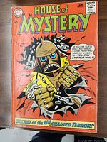 Front cover of House of Mystery No. 150 comic showing the main character breaking chains against an orange background with title text.