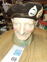 Front view of the Royal Doulton Monty Toby mug head figurine showing face, beret with leaf emblem, and collar.