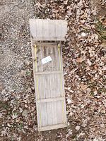 Top down view of wooden sled showing length and slatted wooden surface with curved front nose