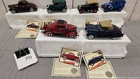 Front overview of all 6 die-cast Ford vehicles on white bases with certificates visible