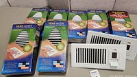 Nine Vent-Miser programmable vents, seven still in original packaging and two unpackaged vents visible.