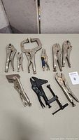 Lot overview showing ten locking pliers and clamps arranged on a table.