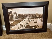 Framed vintage black-and-white photo showing Victoria's Inner Harbour with boats and horse-drawn vehicles in early 20th century style, dark wood frame.