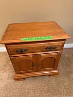 Front view of the Roxton mid-century maple night stand showing the drawer with metal handles and two-door cupboard below with arch panel details.
