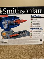 Box front displaying Smithsonian Jet-Works logo, image of jet engine model, and features including battery operation, moving parts, lights, and included color poster.