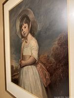Close angle of framed impressionist-style portrait of young girl in white dress and hat, highlighting texture and colors.