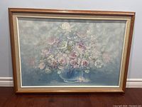 Full framed painting depicting a floral bouquet in a vase with soft blues and pastel tones.