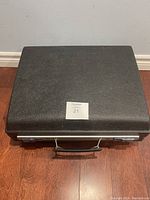 Closed black hard case containing the typewriter