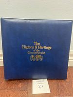 Blue binder with gold embossed title on cover, photographed against wall.