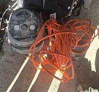 Front view of Porter Cable air compressor with attached orange hose in dusty, outdoor setting.
