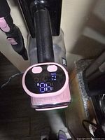 Top view of pink digital vacuum displaying speed setting and controls digitally on the handle, showing it is functional.