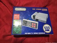 Front of box showing image of console and controller, branding, and features including 600 games and HD 1080P output support.