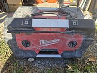 Front view of Milwaukee jobsite radio showing controls, brand logo, and top handle