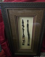 Full frontal photo of the decorative shadow box showing two tribal wooden figures inside the framed case.