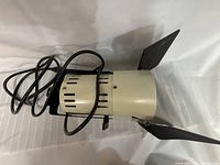 Side view of one Smith Victor lamp showing beige housing with vents and attached barn doors.