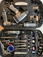 Wide view of open tool case showing multiple Nikota pneumatic air tools including air hammer, air ratchet, nailer, die grinder, sockets, fittings, and polishing stones in molded black plastic case.
