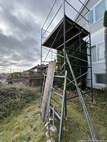 Assembled two-tier scaffolding with boards leaning against it