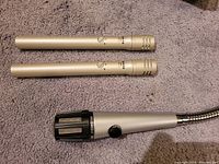 Two SM81-LC pencil condenser microphones and one 515SBG-18X gooseneck microphone laid on carpet