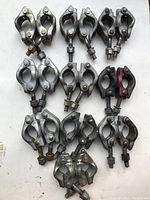 Top view of all 10 swivel scaffolding clamps arranged in groups on a flat surface, showing their general condition and design.