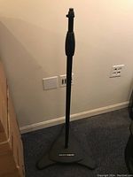 Full view of the black tripod microphone stand showing height and base design.