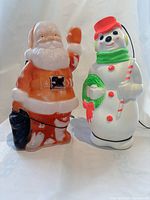 Front view of a red Santa Claus and a snowman blow mold showing color and detailing