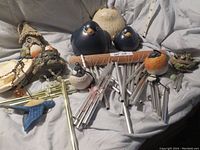 Bluebird and winter bird figurines with multiple metal wind chimes on a light cloth background