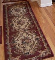 Photo of Cameo Rose floor runner with floral medallion design on hardwood floor, showing entire rug length and pattern details.