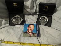 Two Mats Jonasson crystal cat paperweights in their boxes with information booklet and measuring tape visible.