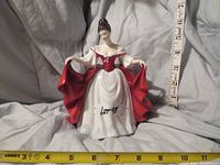 Front view of the Royal Doulton 'Sara' porcelain figurine with measuring tapes showing size about 9 inches tall.