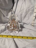 Front view of pear-shaped crystal sculpture with measuring tapes