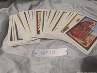 Front side of tarot cards showing colorful religious-themed illustrations including a saint with a staff, labeled as 'X. A Hermit or Penance | The Hermit'.