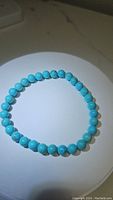 Photo of natural robin's egg blue turquoise bracelet laid flat showing round polished beads.